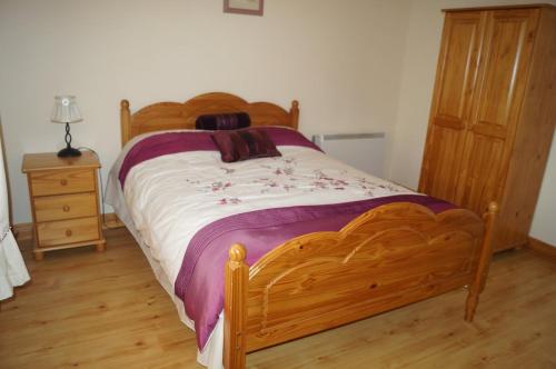 a bedroom with a wooden bed and a wooden dresser at Apartment No. 3 Bunbeg in Bunbeg