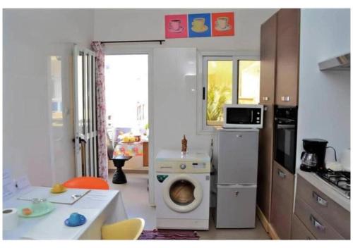 a kitchen with a washing machine in the middle of a room at Chez Ouly in Dakar