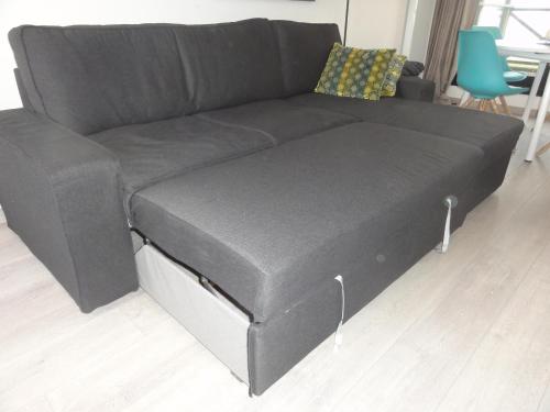 a black couch in a living room at La Naturelle Duplex 90 in Wimereux