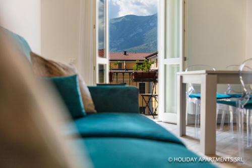 ein Wohnzimmer mit einem blauen Sofa und einem Tisch in der Unterkunft Diamond Apartments in Bellagio