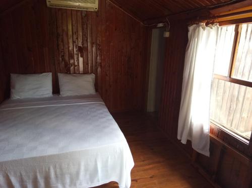 1 dormitorio con cama blanca y ventana en Don Kişot Olimpos Hotel, en Olympos