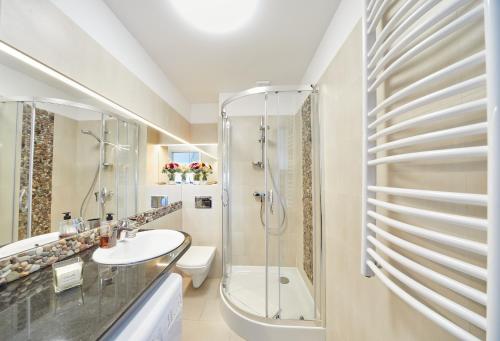 W łazience znajduje się prysznic, umywalka i toaleta. w obiekcie Porta Mare Apartments LuxView III w Dziwnówku