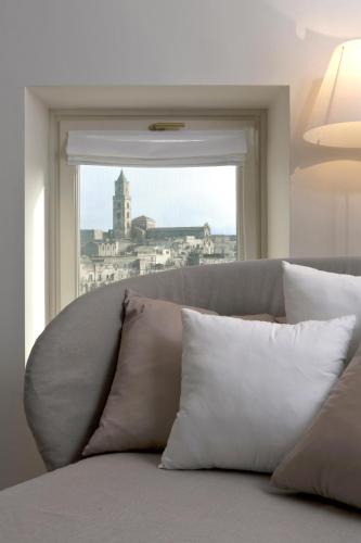 a couch with pillows sitting in front of a window at Santa Cesarea Residence Luxury Suite - La vetta del Sasso Barisano in Matera
