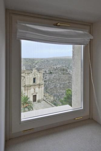 a window with a view of a building at Santa Cesarea Residence Luxury Suite - La vetta del Sasso Barisano in Matera