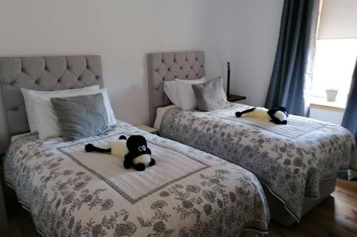 two beds with stuffed animals laying on them in a bedroom at The Apartment in Aberlour in Aberlour