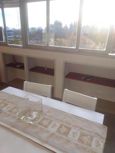 a table and chairs in a room with windows at Depto Plaza Moreno in La Plata
