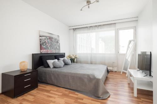 um quarto branco com uma cama e uma televisão em City Star em Jyväskylä