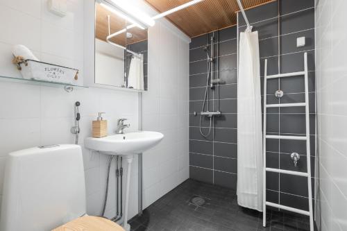 uma casa de banho com um lavatório e um chuveiro em City Star em Jyväskylä