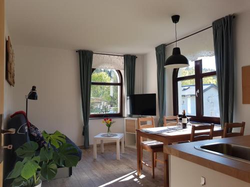 a kitchen and living room with a table and a dining room at Ferienwohnung Wegespinne in Zwota