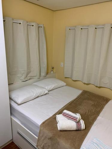 a bedroom with two beds with towels on them at Pousada Cipó Container Chalés Privativos com lareira - Centro da cidade in Serra do Cipo