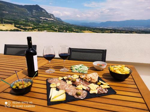 a table with a plate of food and two glasses of wine at La Terrazza in Collina in San Gemini