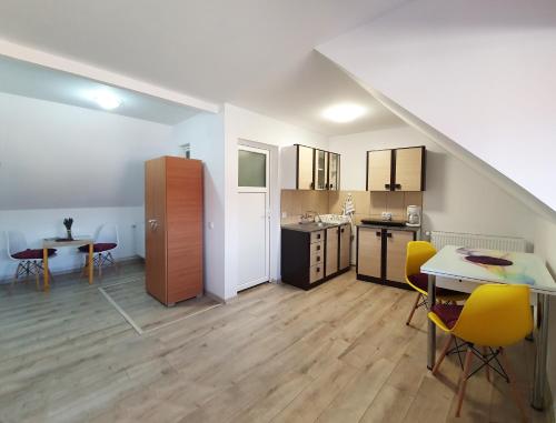 cocina y comedor con mesa y sillas amarillas en Lavender Apartments en Sînpetru