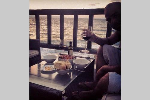 a couple sitting at a table with a glass of wine at ROMANTIC HOUSE 6 STEPS FROM THE SEA in Mochlos