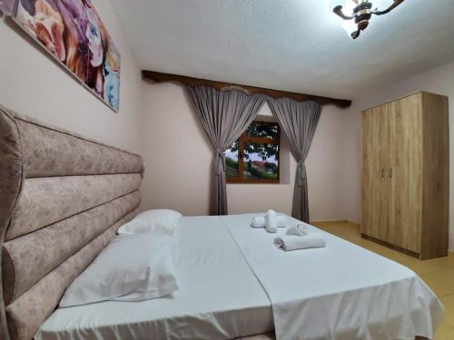 a bedroom with a bed with towels on it at Vila Emilio in Udënisht