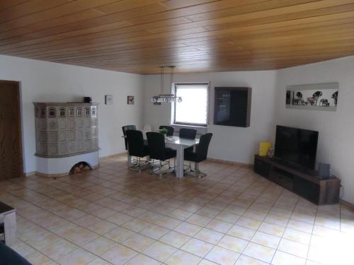 a living room with a table and chairs and a television at A25 FeWo 180qm mit 5 Schlafzimmer, 2 Badezimmer für bis zu 8 Personen in Abstatt