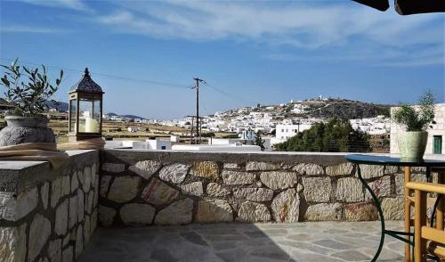 a stone wall with a table and a lamp at Argento in Kimolos