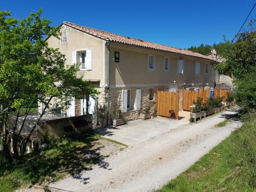 ein Haus auf einer unbefestigten Straße neben einem Zaun in der Unterkunft Les gîtes de Moussan in Montbrun-les-Bains