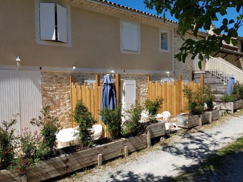 a fence with a bunch ofotted plants in front of a house at Les gîtes de Moussan in Montbrun-les-Bains