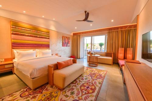 a bedroom with a large bed and a living room at Four A Resort Jammu in Khairi