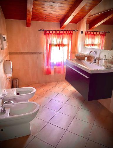 a bathroom with two toilets and a sink and a window at Agriturismo le tre stelle in Paestum