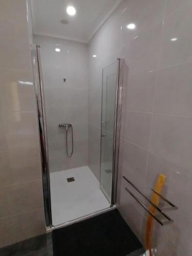 a shower with a glass door in a bathroom at Alojamentos Martinho in Quintas