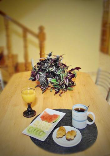 a table with a cup of coffee and a plate of food at Casa centro o grove con terraza y asador in O Grove