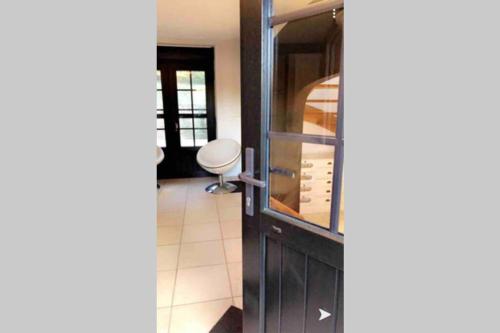 a door to a wine cellar with a chair behind it at Le petit haut de Meuse in Profondeville