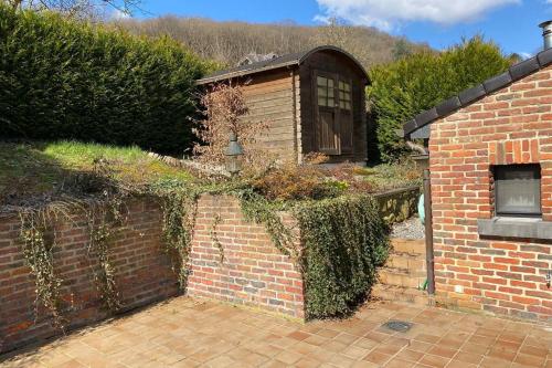 a brick wall with a building in a yard at Le petit haut de Meuse in Profondeville
