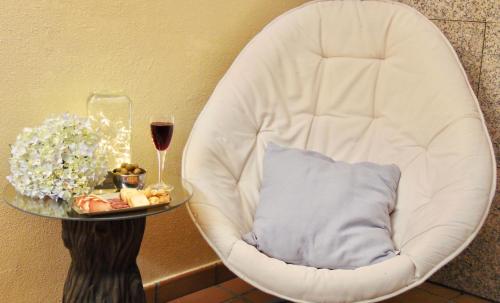 a white chair with a plate of food and a glass of wine at Casa centro o grove con terraza y asador in O Grove