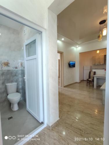 a bathroom with a toilet and a room with a kitchen at Kochalidze family in Batumi