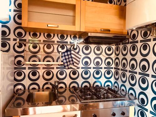 eine Küche mit einem Herd und einer schwarz-weißen Wand in der Unterkunft MAD di Mare di Arte Dormire in Celle Ligure