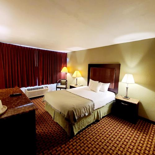a hotel room with a large bed and a desk at Town Inn in Bordentown