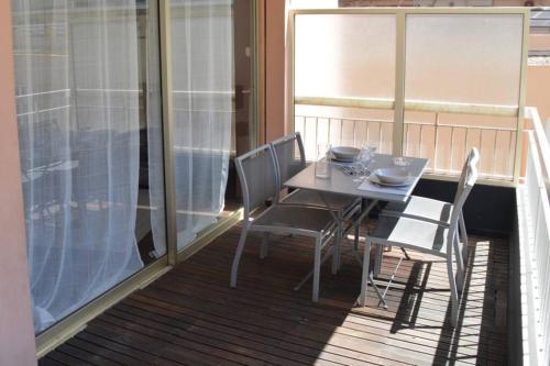 un balcon avec une table et des chaises sur un balcon dans l'établissement Grand studio climatisé proche plages Juan les pins, à Antibes