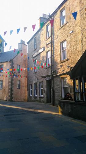 una calle con banderas y edificios y una calle con un edificio en Queens Hotel en Lerwick