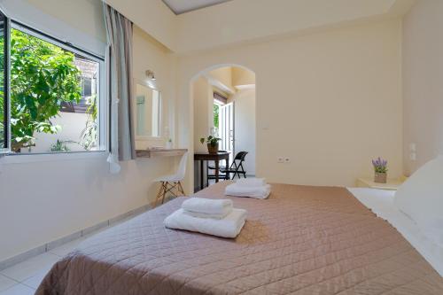 a bedroom with a bed with two towels on it at Geana Apartments in Chania