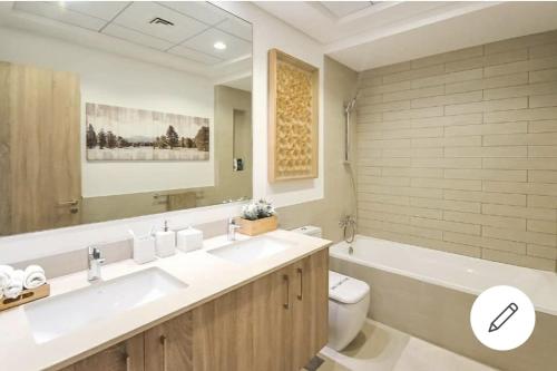 a bathroom with a sink and a toilet and a tub at TOWN SQUAR PARK VIEW in Dubai