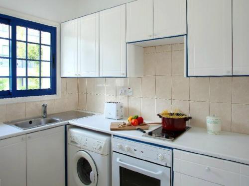 una cucina bianca con lavastoviglie e lavello di Villa Julie a Protaras