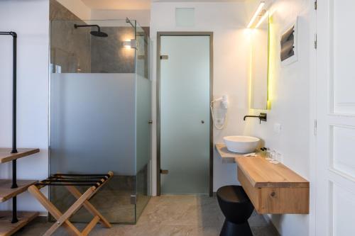 a bathroom with a glass shower and a sink at Magas Hotel in Mýkonos City