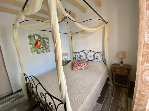 a bedroom with a four poster bed with a canopy at Petridi Maria Suites & Apartments in Patmos