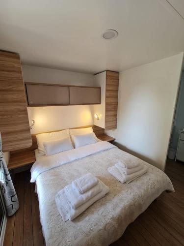 a bedroom with a large bed with two towels on it at Mobile Homes Adriatic , Campsite Porton Biondi -Rovinj in Rovinj