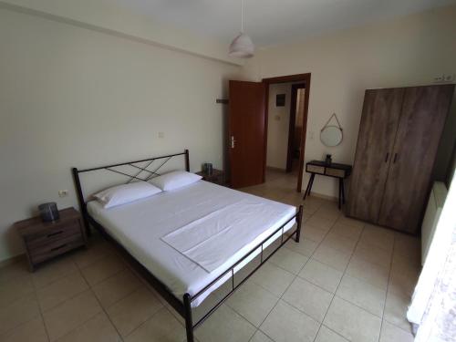 a bedroom with a large bed and a wooden cabinet at Elena House in Néa Péramos