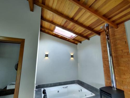 a bathroom with a bath tub in a room at Chalé dos Pássaros in Gramado