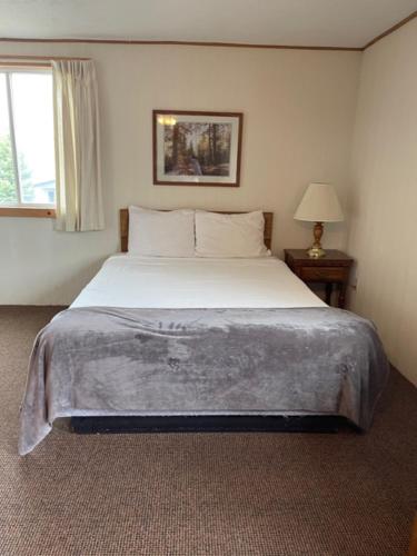 a bedroom with a large bed and a window at The Terrace Motel in Munising