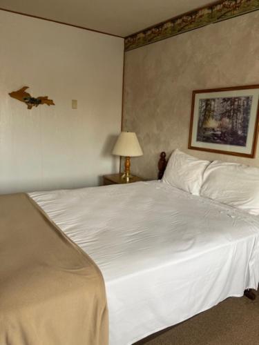 a bedroom with a white bed with a bird on the wall at The Terrace Motel in Munising