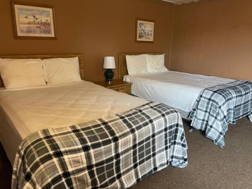 a hotel room with two beds and a lamp at The Terrace Motel in Munising