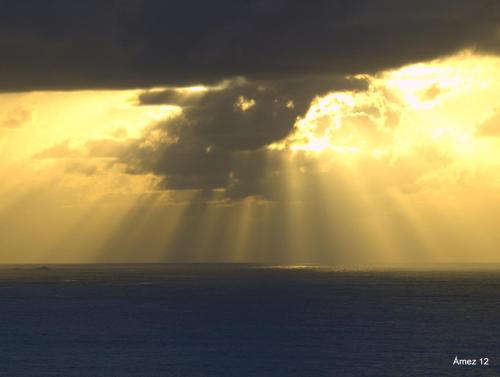 a sun shining through the clouds over the ocean at HOTEL LA CASA DE LAS CAMELIAS in Busto