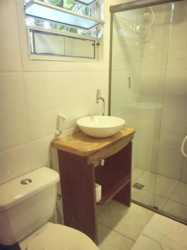 a bathroom with a sink and a toilet and a shower at Pousada Alfa e Ômega in Alto Paraíso de Goiás