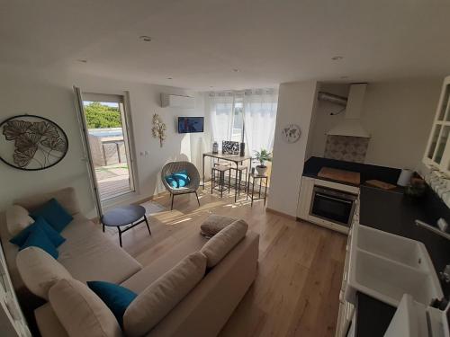 Il comprend un salon avec un grand canapé et une cuisine. dans l'établissement confortable appartement T2, à La Grande Motte
