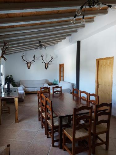 ein Esszimmer mit einem Holztisch und Stühlen in der Unterkunft CORTIJO EL PRADO ll in Castril