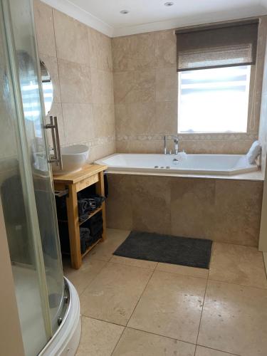 a bathroom with a bath tub and a sink at Craster Crew Quarters in Craster